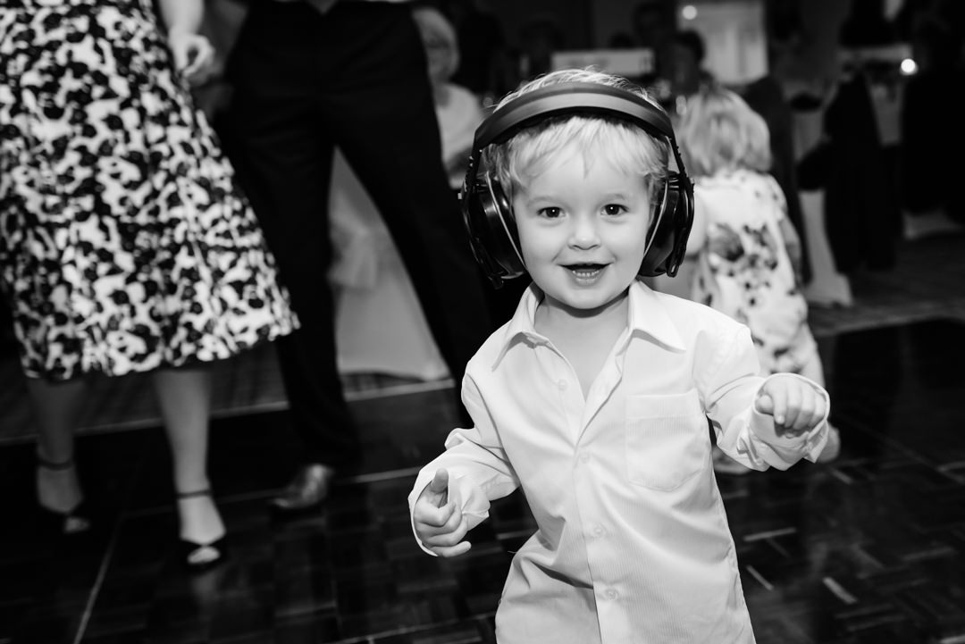 kids wears ear protector and dances as the wedding band begin to play at harpenden golf club wedding