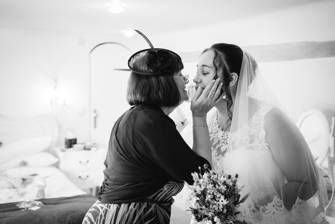 hertfordshire wedding photographer captures mother of bride giving a little kiss