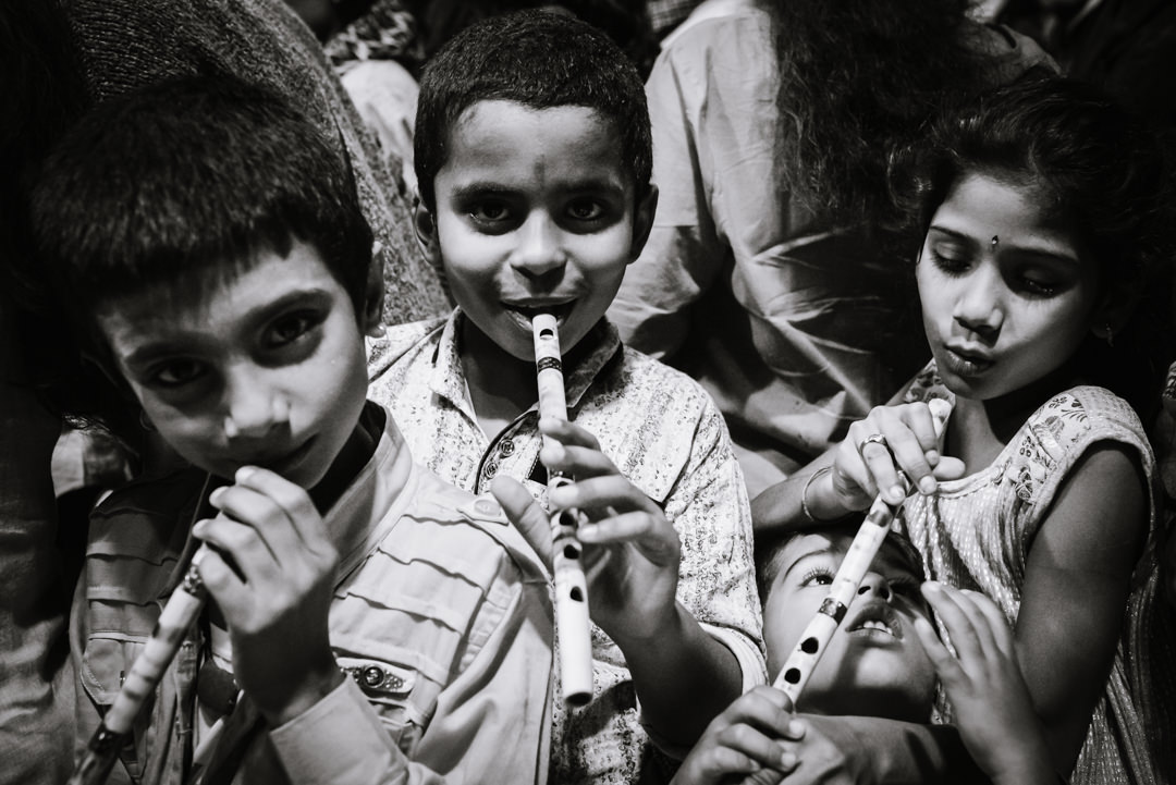 street photographer and kids playing their recorders at ghats varanasi