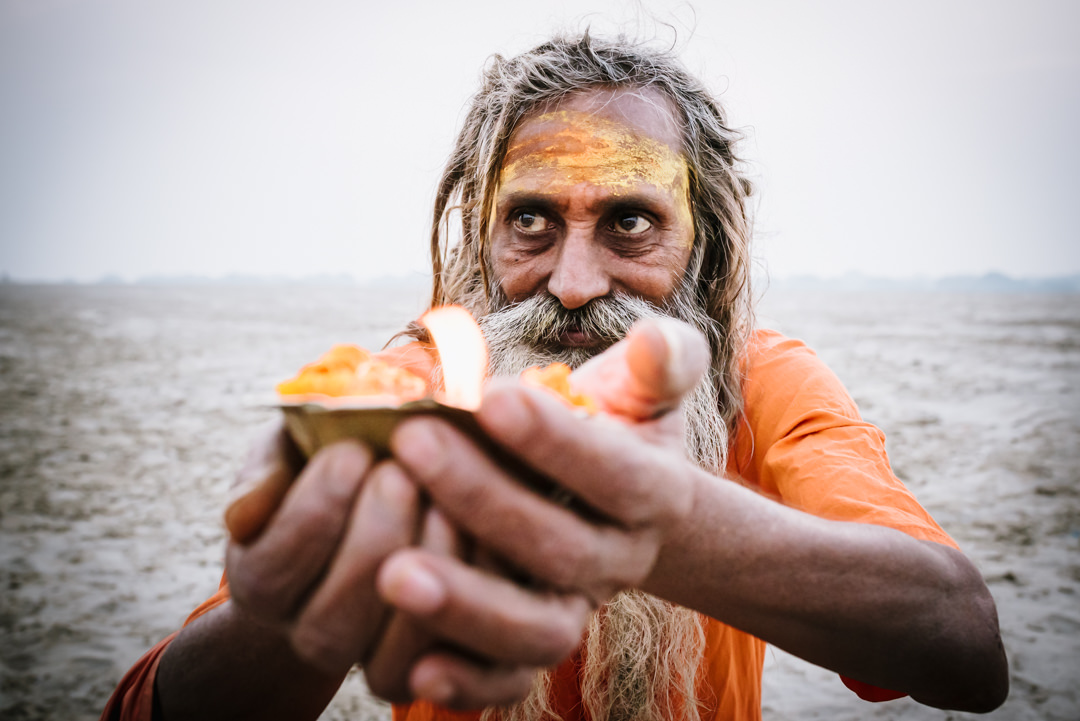 holy man holds candle for varanasi street photography course members