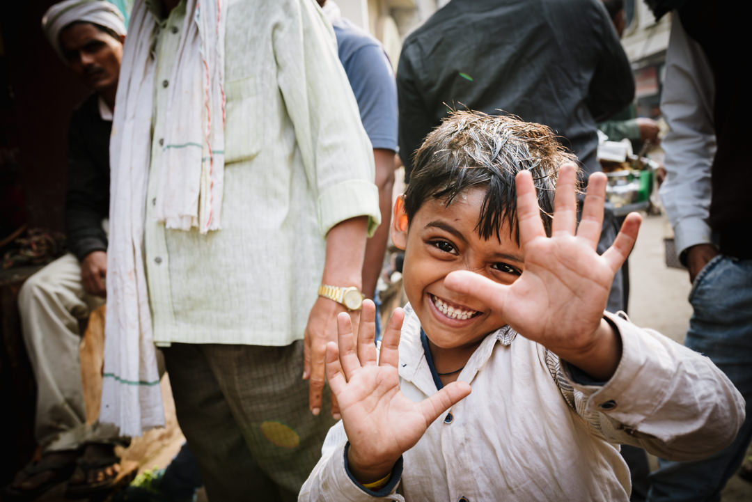 indian kid tries to hide from varanasi street photographers