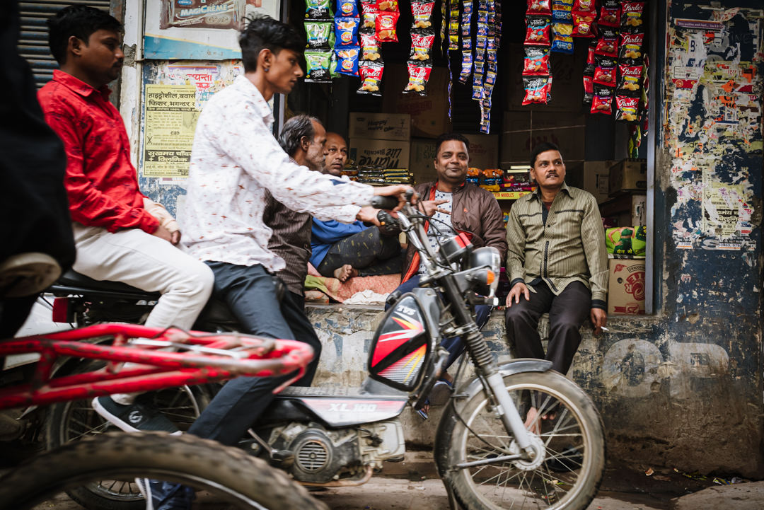 varanasi street filled with motorbikes and men