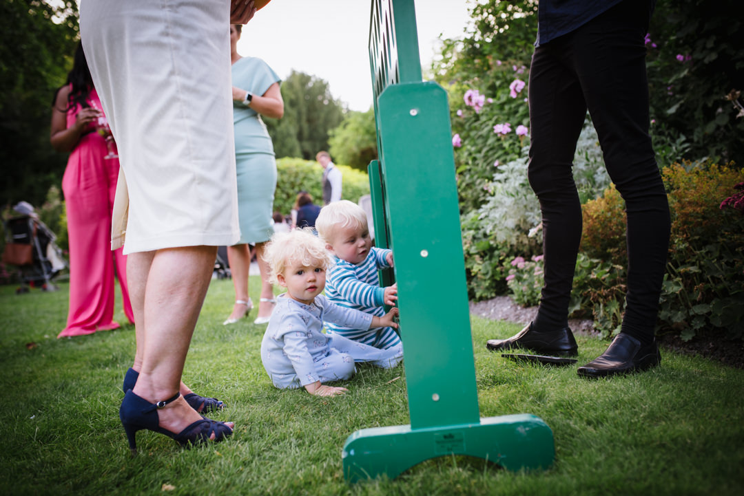 the youngest guests at sheene mill wedding enjoy connect 4 amongst other wedding guests legs
