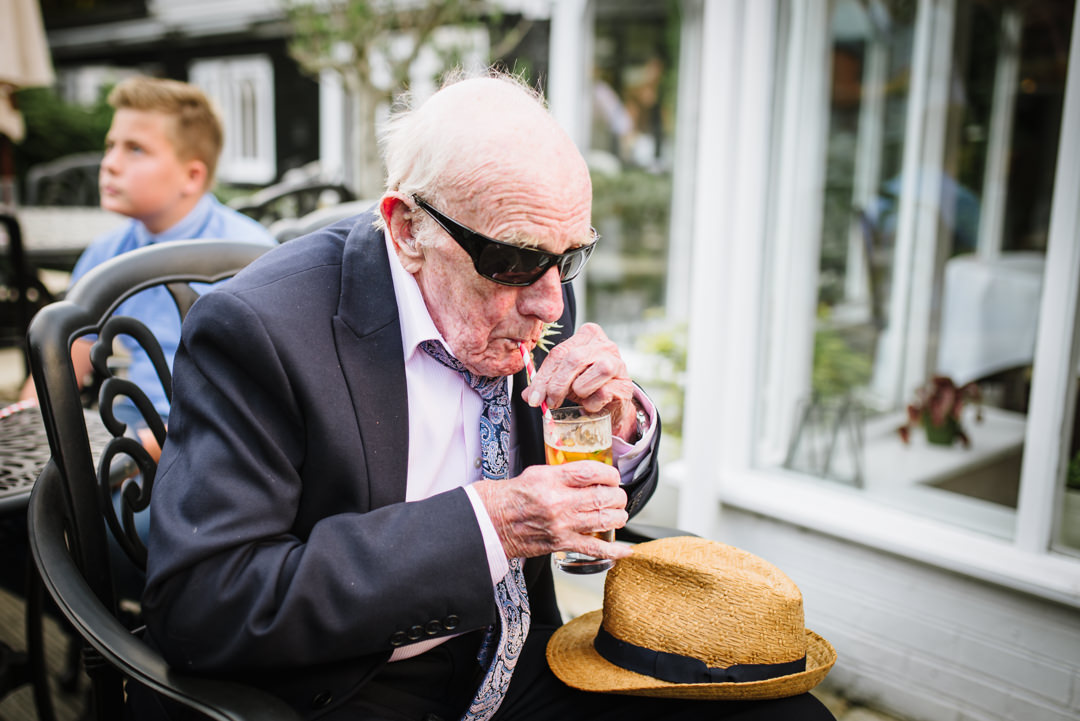 granddad enjoys a glass of pimms at sheene mill wedding