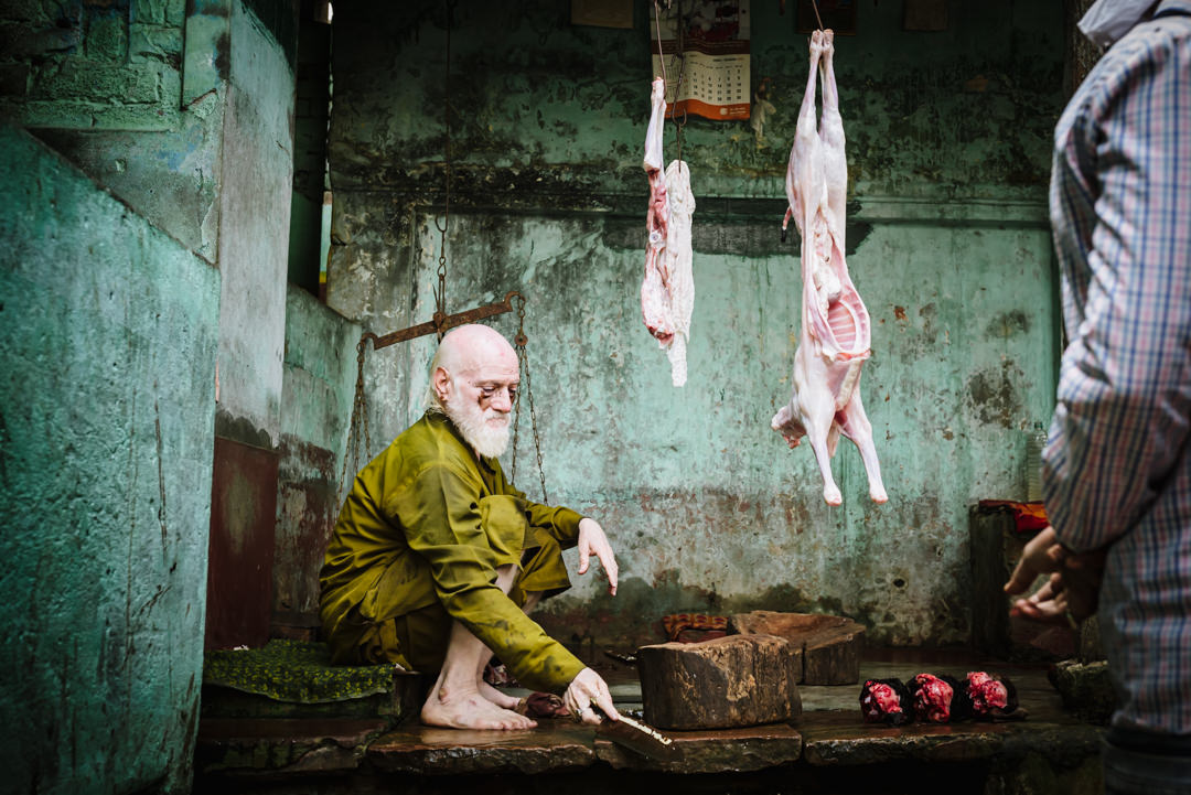 Varanasi street market where seller sharpens his knives