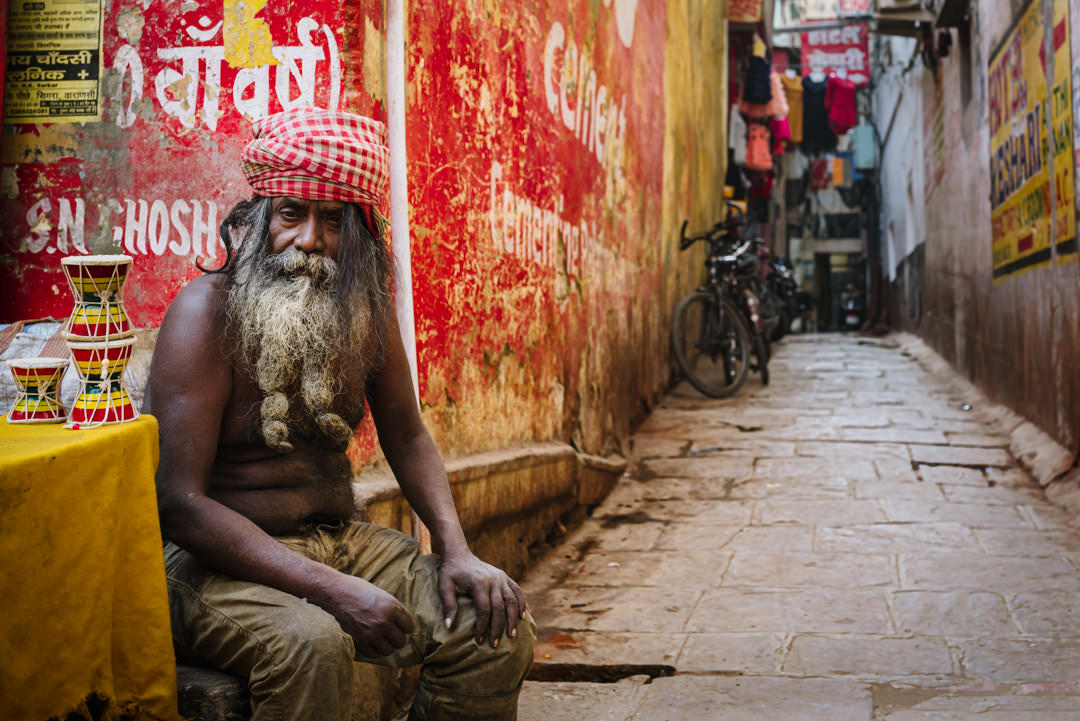 brightly dressed holy man in varanasi street in india