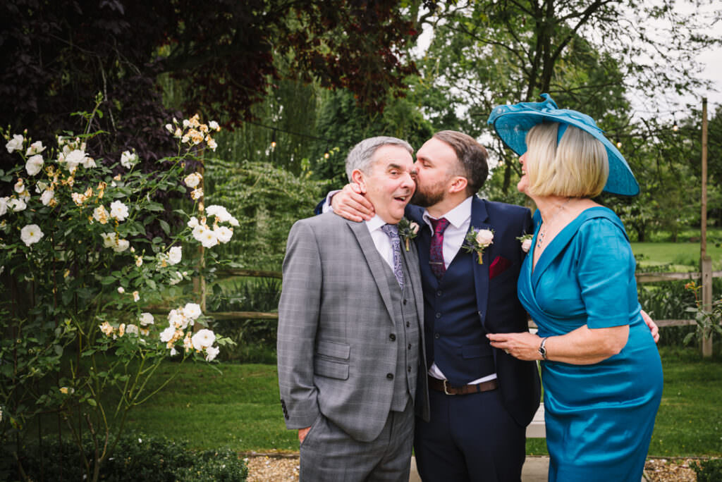 groom kisses his dad at houchins wedding 