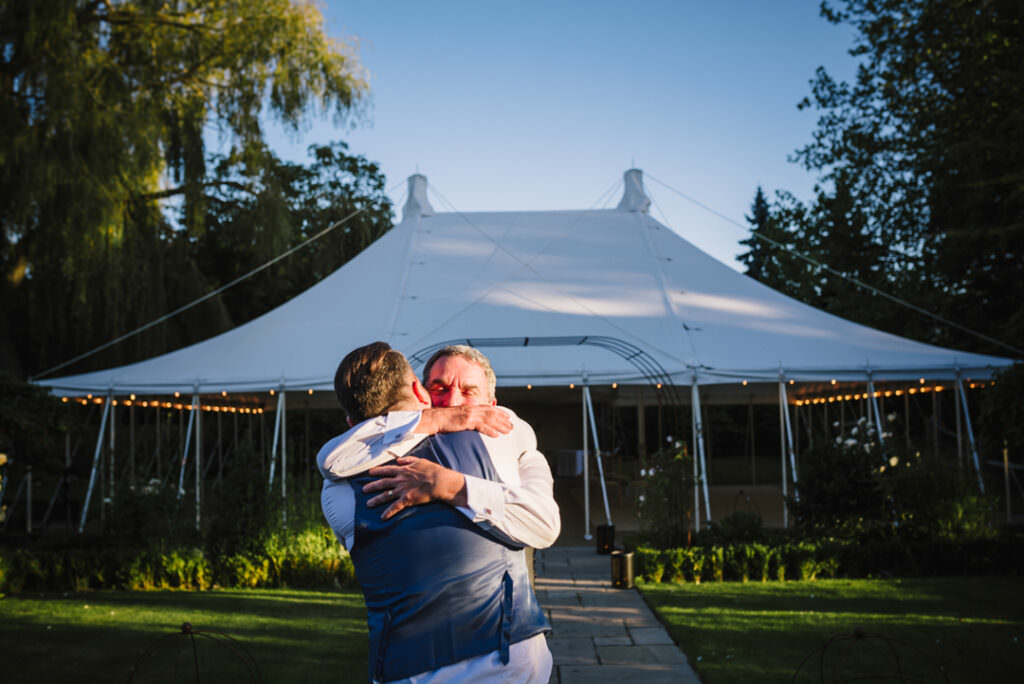 father and son hug at houchins farm wedding