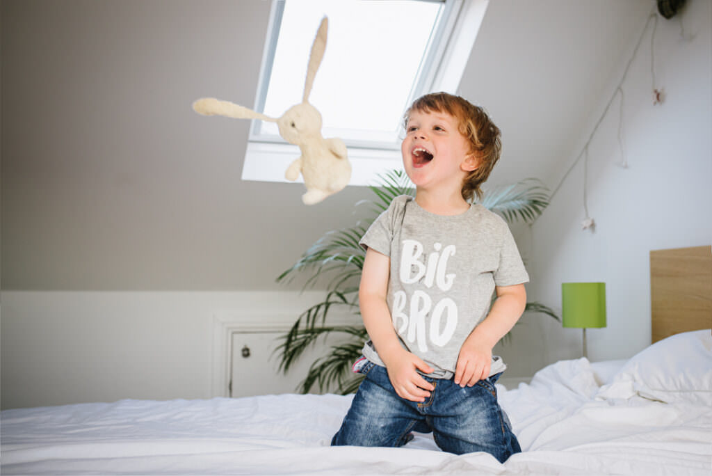 young boy throws his bunny during his hertfordshire newborn photographer session