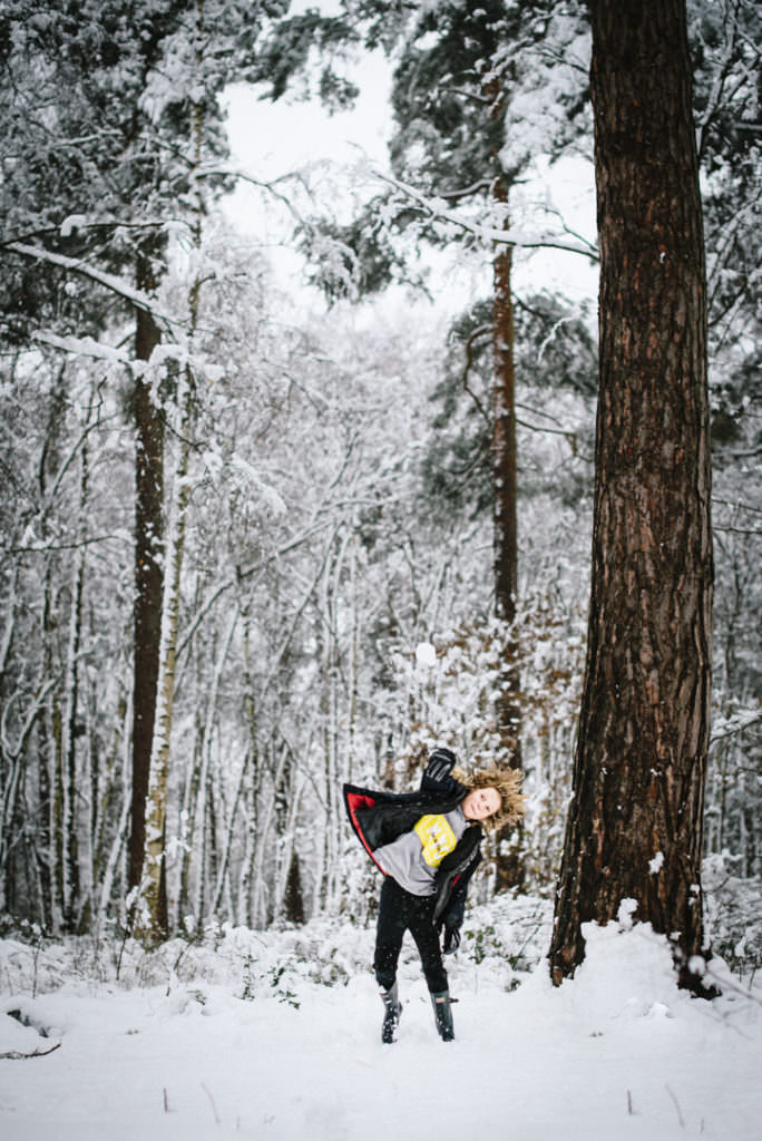 hertfordshire child throws snow balls in the woods