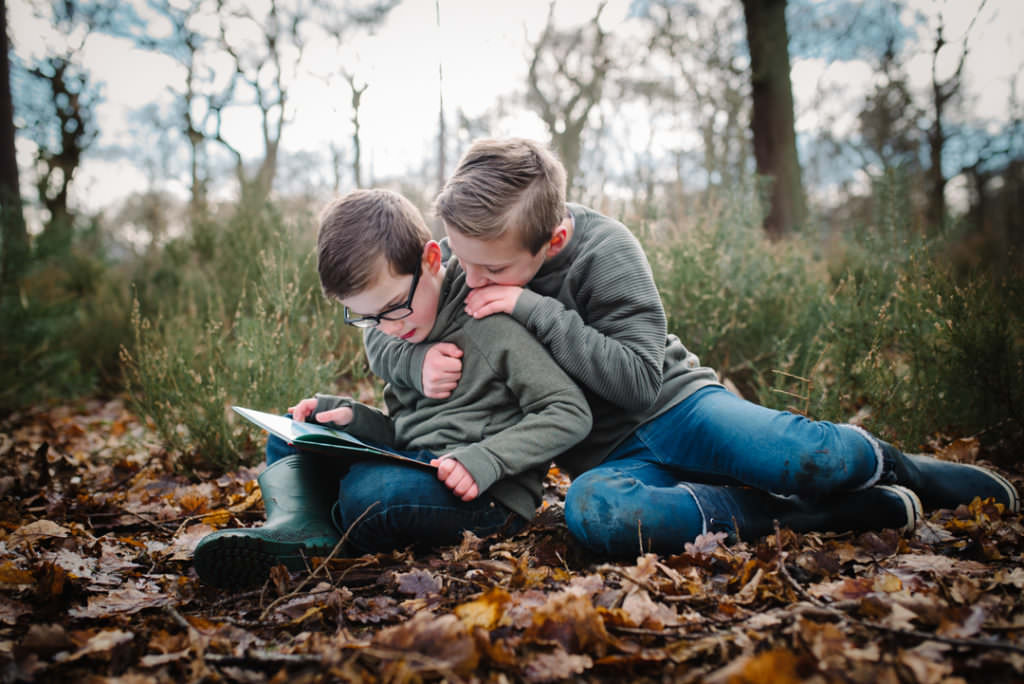 two brothers share a book during their hertfordshire family photoshoot