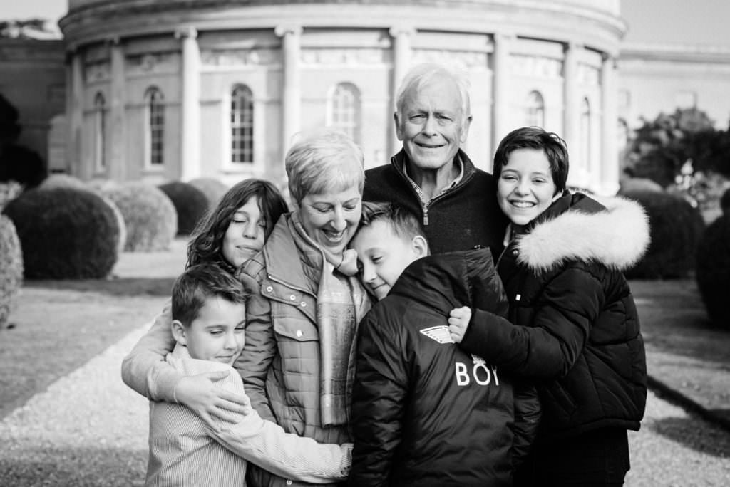 grandchildren hug their grandparents during their winter family photoshoot