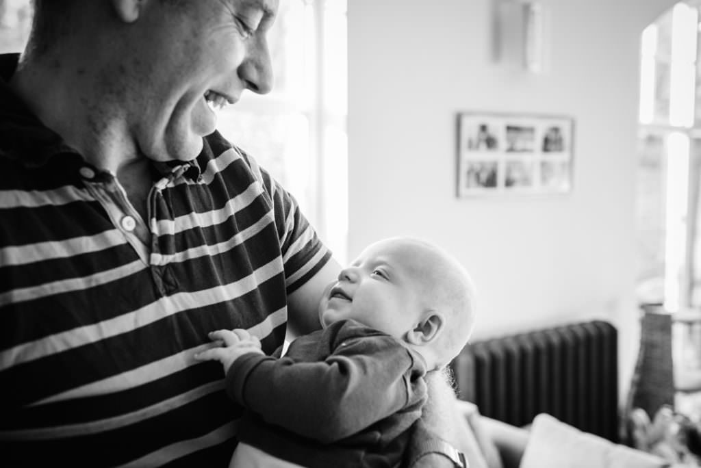 newborn and his dad look lovingly at each other