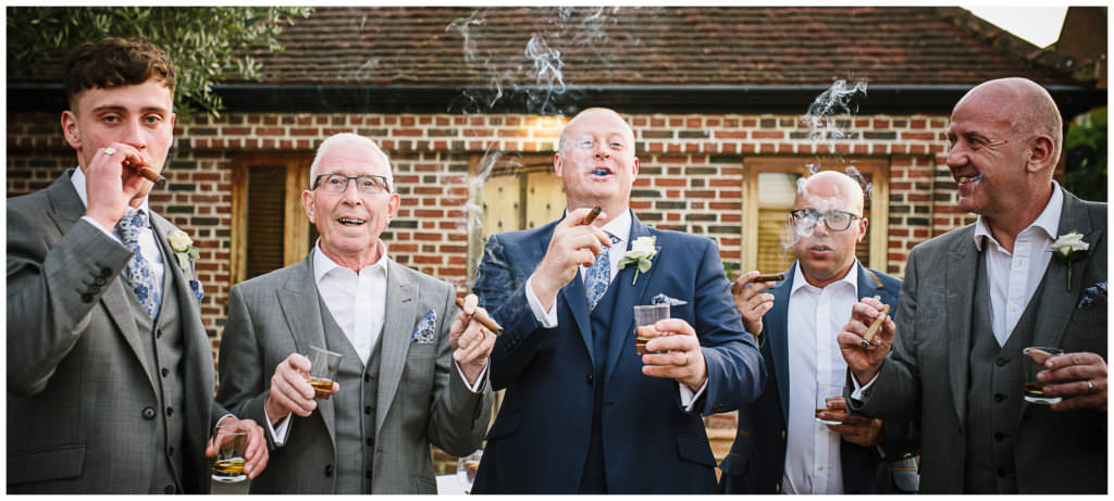wedding guests enjoy cigars and brandy at small wedding venue 