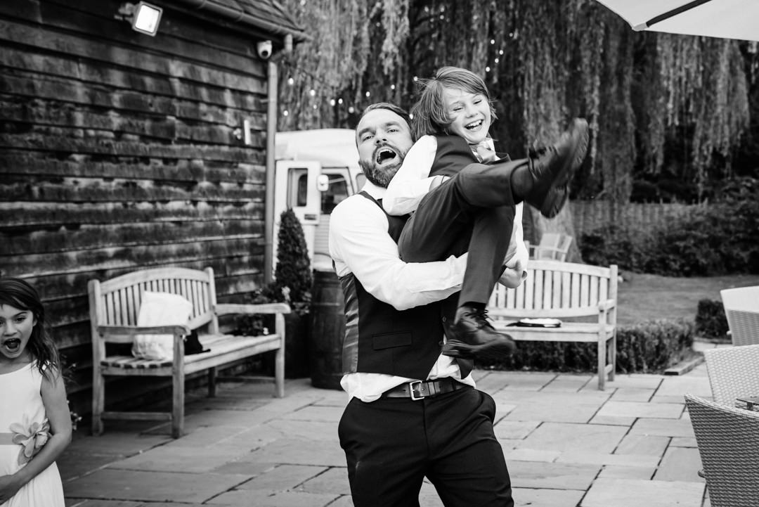 Hertfordshire wedding photographer captures groom throwing nephew at houchins wedding in 2020