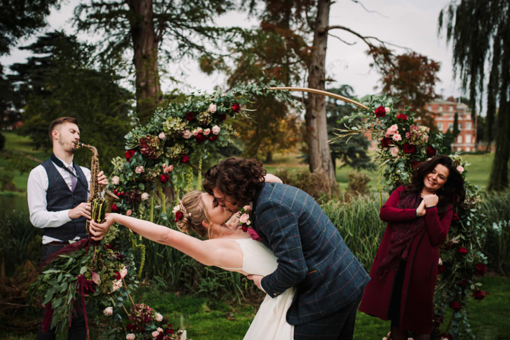 bride and groom kiss at their outdoors wedding in the grounds of brocket hall