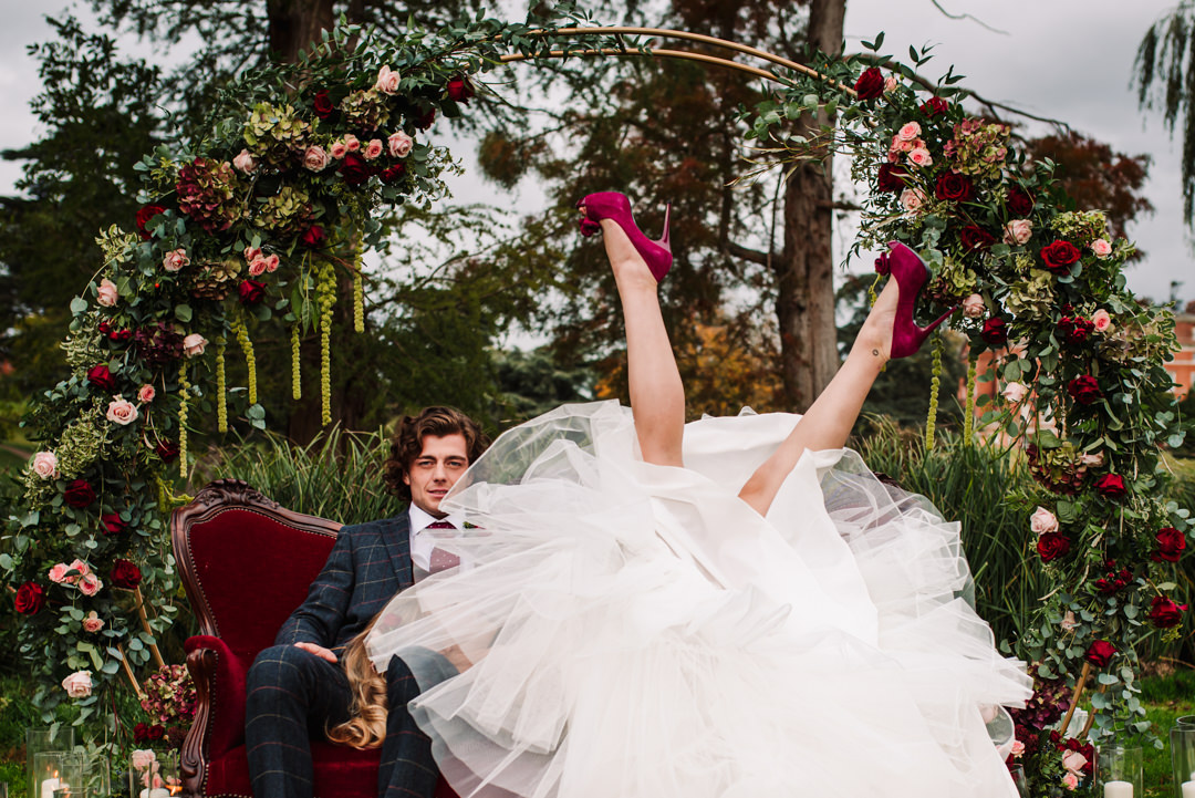 fun photography of bride kicking her legs up at brocket hall wedding