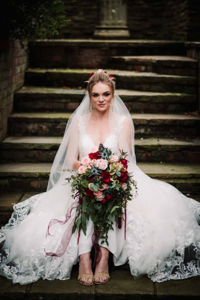 bride sitting on steps at hertfordshire wedding