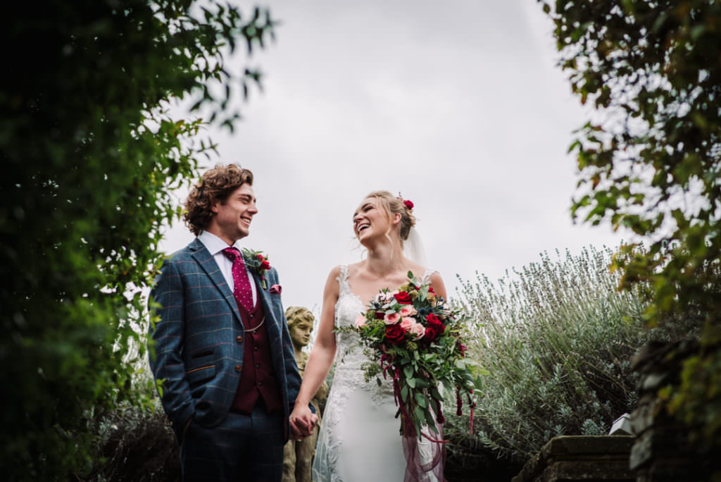 bride and groom share a joke whilst posing for their hertfordshire wedding photography