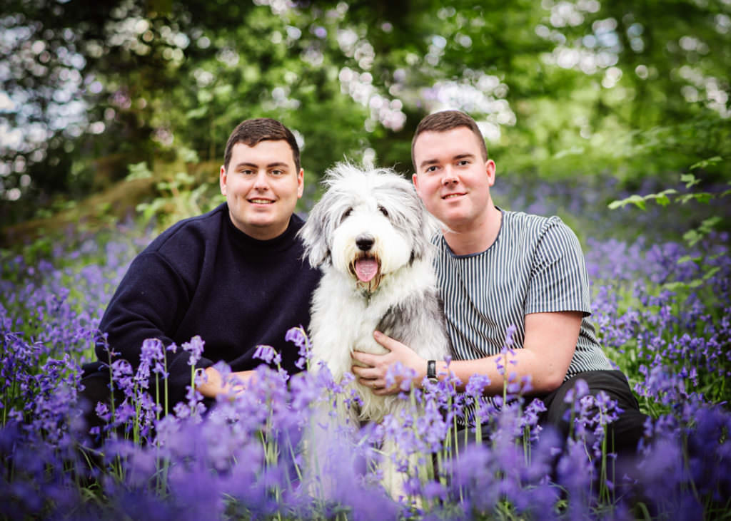 couple and their dog sit amongst the bluebells in hertfordshire