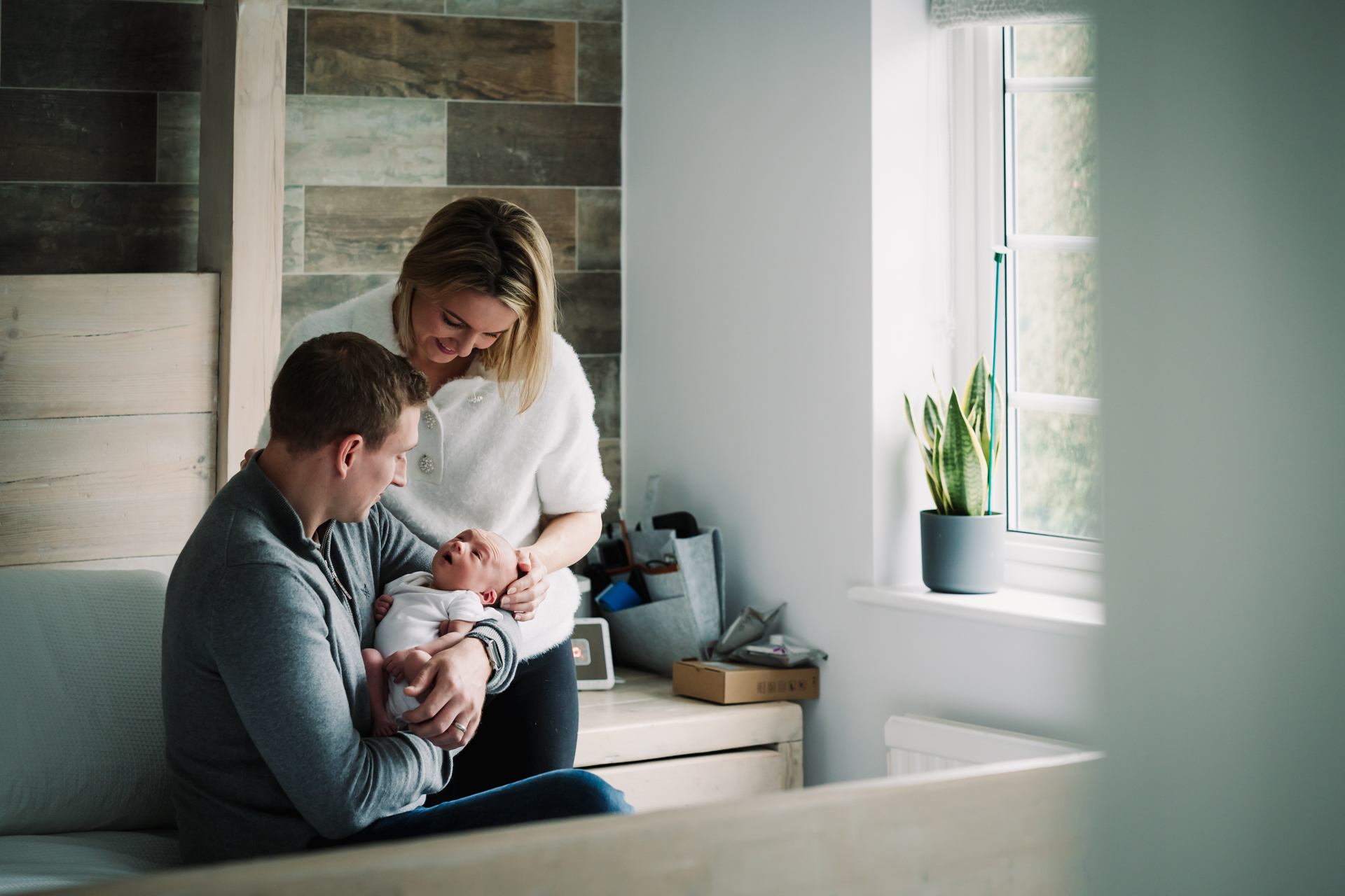 A natural tender moment between new parents and newborn baby in natural light in Hertfordshire