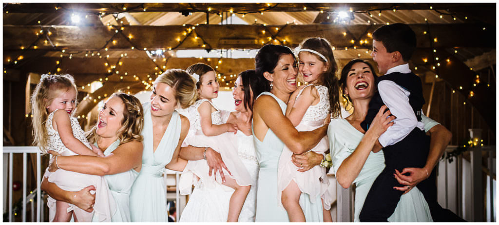bridesmaids hold all the children during a wedding group photo at milling barn hertfordshire