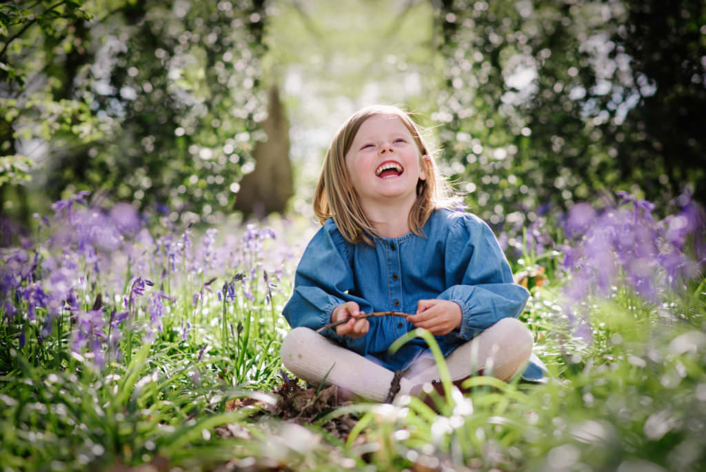 young girl laughs in welwyn garden city bluebell woods