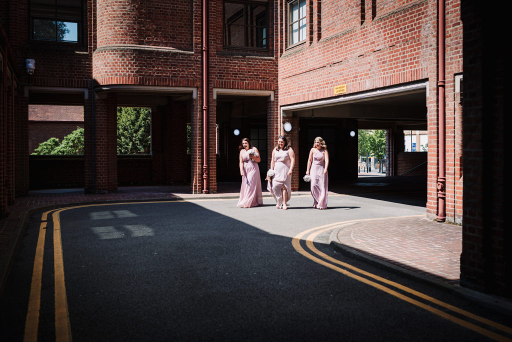 bridesmaids make their way through uxbridge registry office for wedding