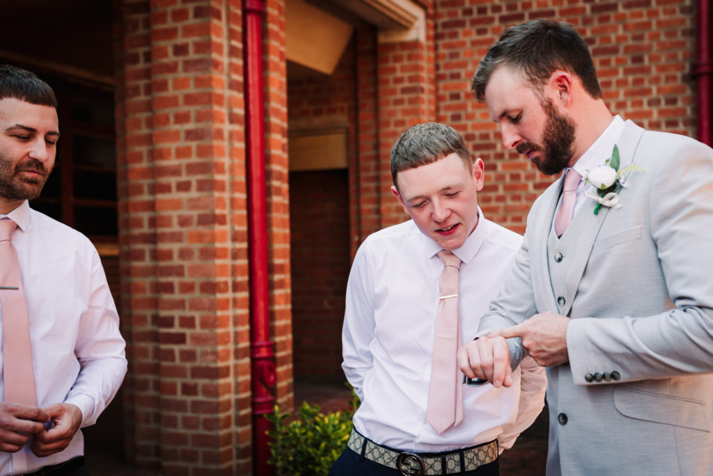 groom and groomsmen check the time before the uxbridge wedding ceremony