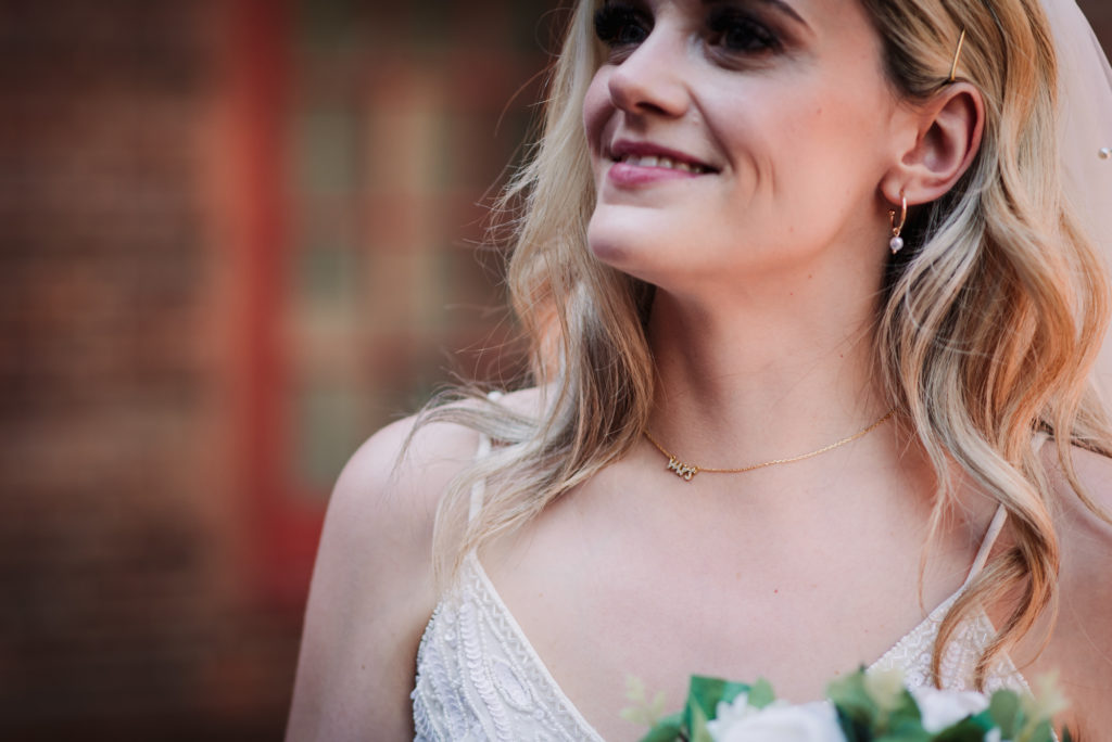 newly wed bride wears a necklace with mrs written on it