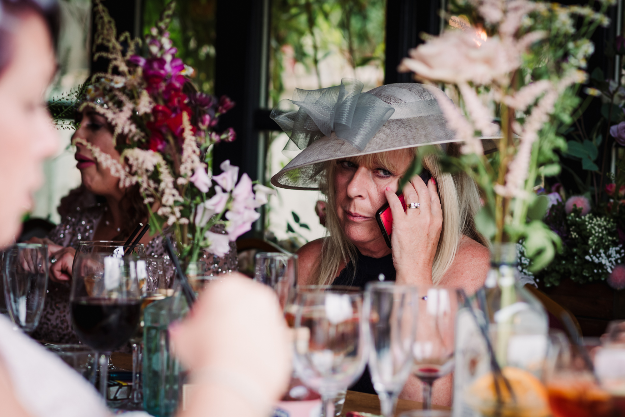 Wedding guest takes a phone call during the pub wedding speeches