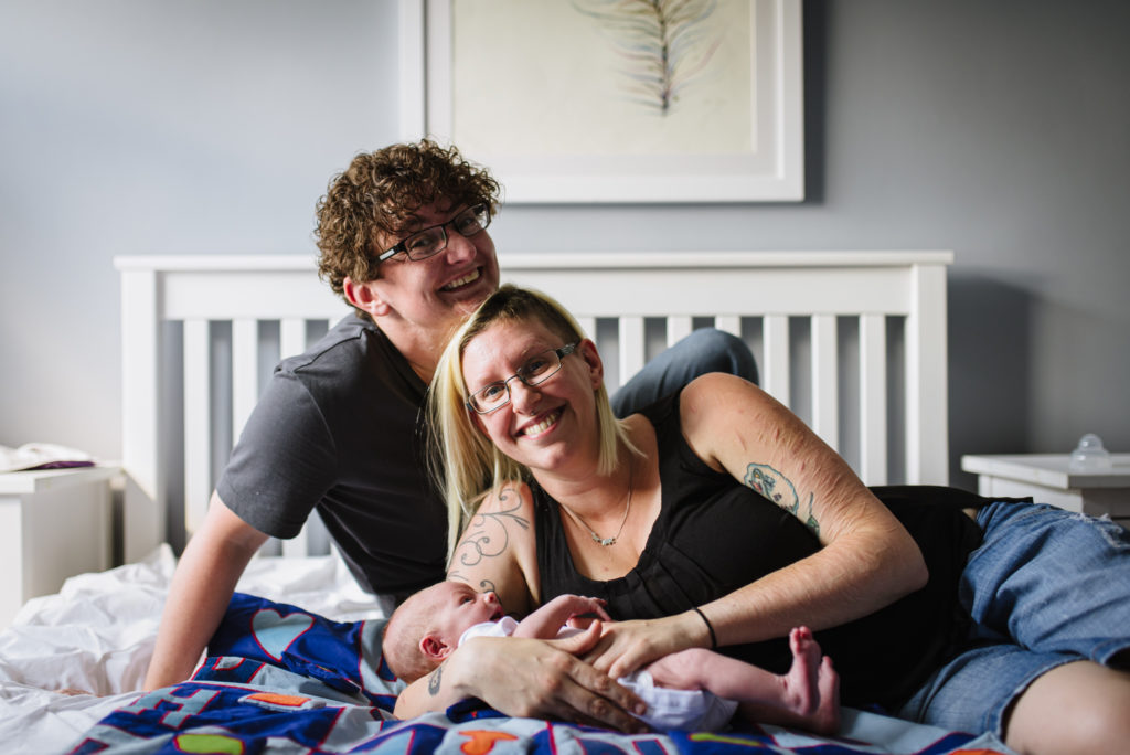 Proud parents hold new baby during their family photography session in Hertfordshire
