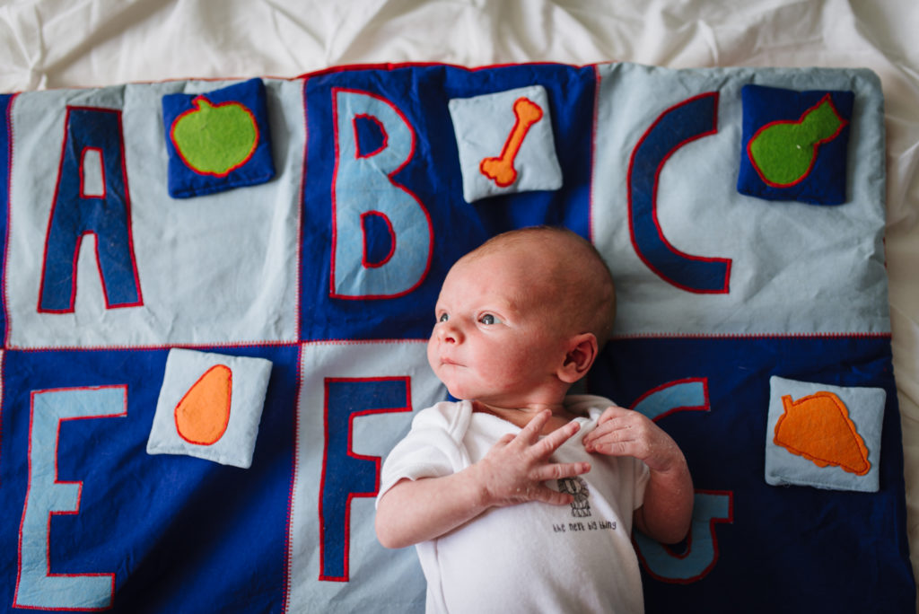 Baby lays on a handmade patchwork quilt during Hertfordshire photography session