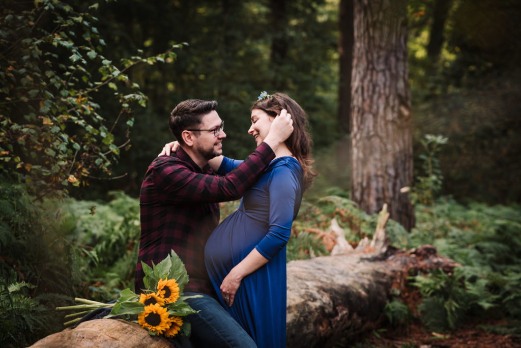 tender moment between parents to be during their maternity photography session in hertfordshire