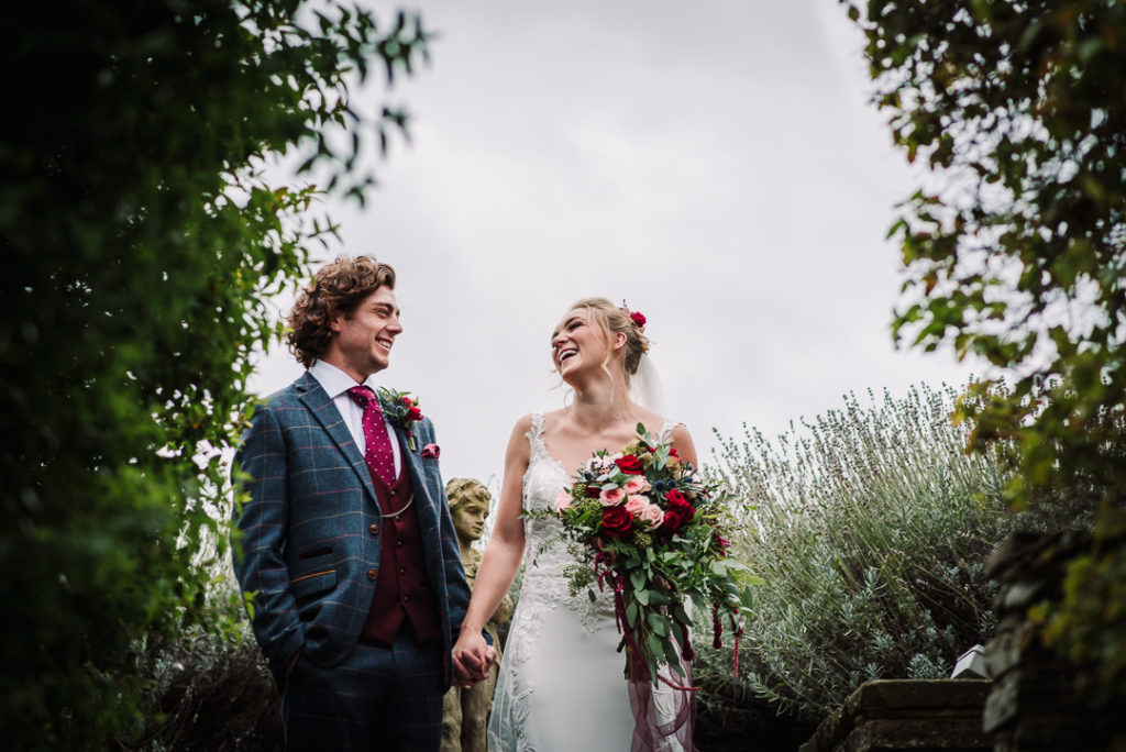 bride and groom share a joke whilst hertfordshire wedding suppliers arrange their wedding