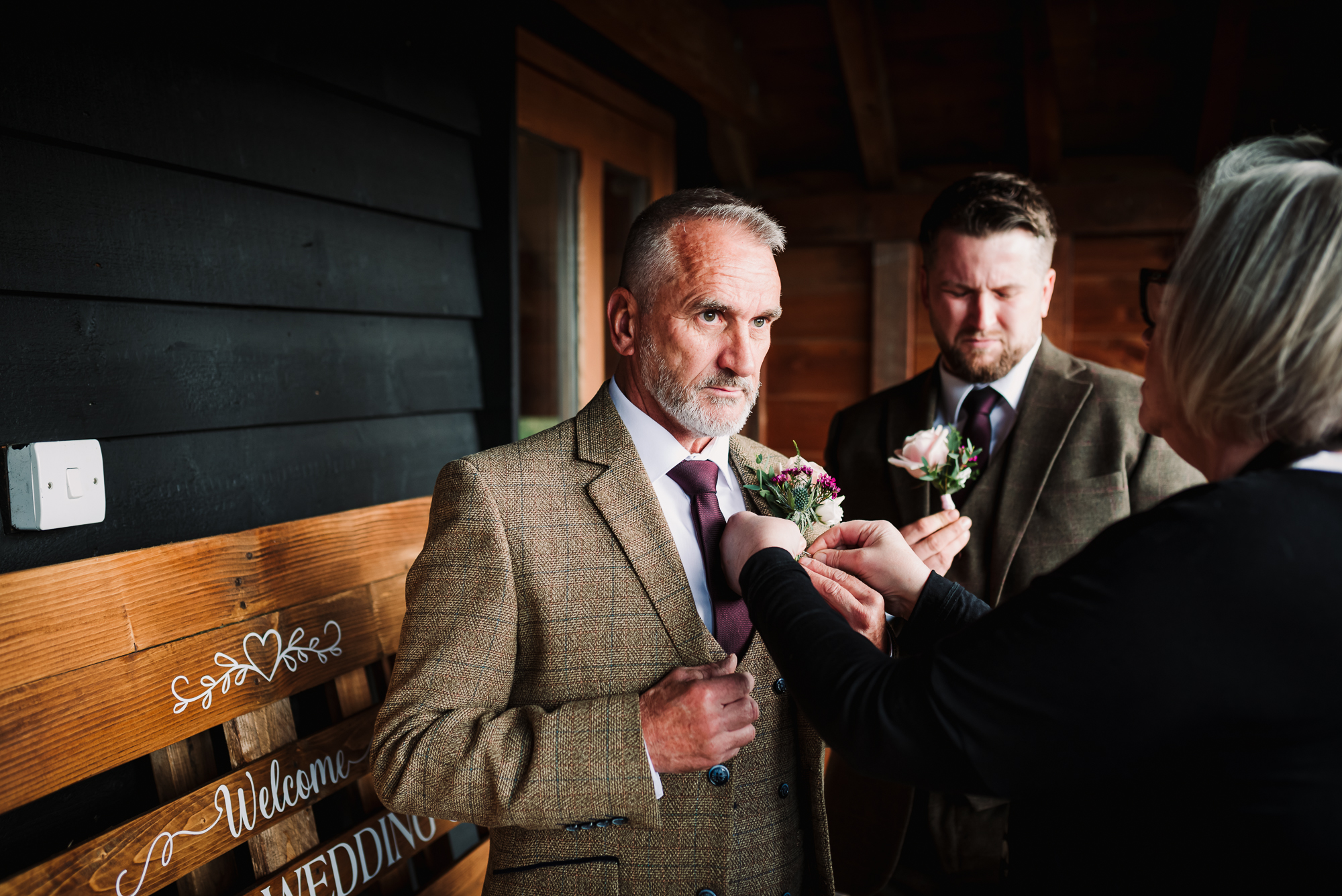 groom adjusts his button hole before his wedding at tewin bury farm hotel