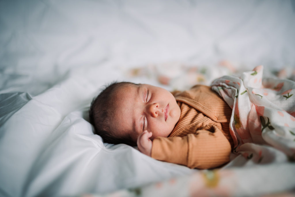 newborn baby sleeps peacefully during her newborn photography session
