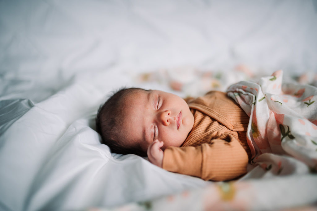 sleeping newborn lies on the bed at home