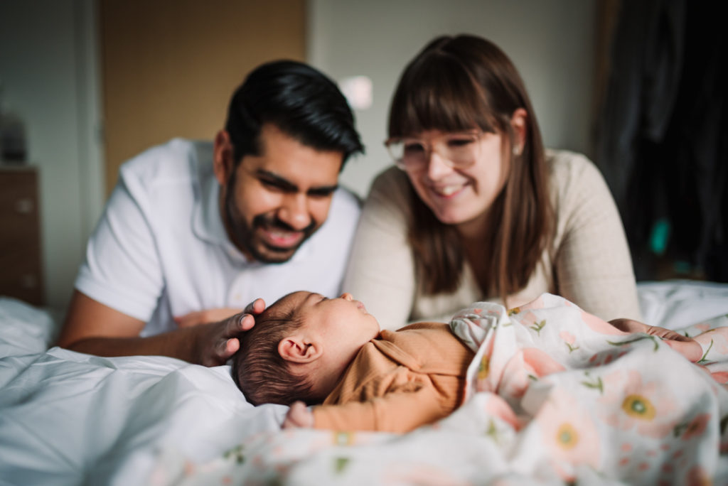 photography capturing proud parents looking over their newborn baby