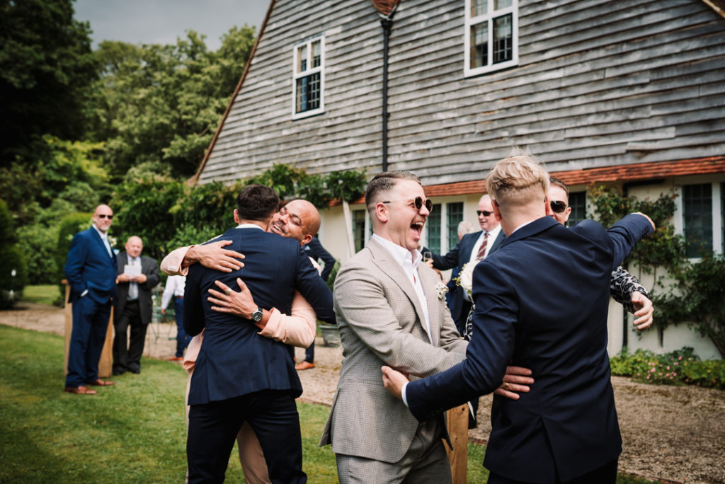 Guests greet each other in the gardens of Hertfordshire wedding
