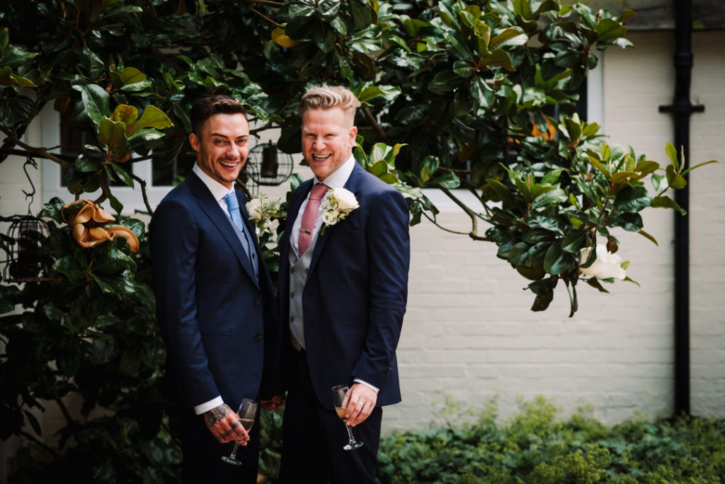 groom and groom have a glass of champagne before their hertfordshire same sex wedding ceremony