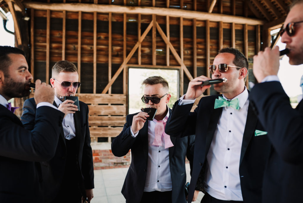 photographer captures groomsmen having a drink at gaynes park wedding