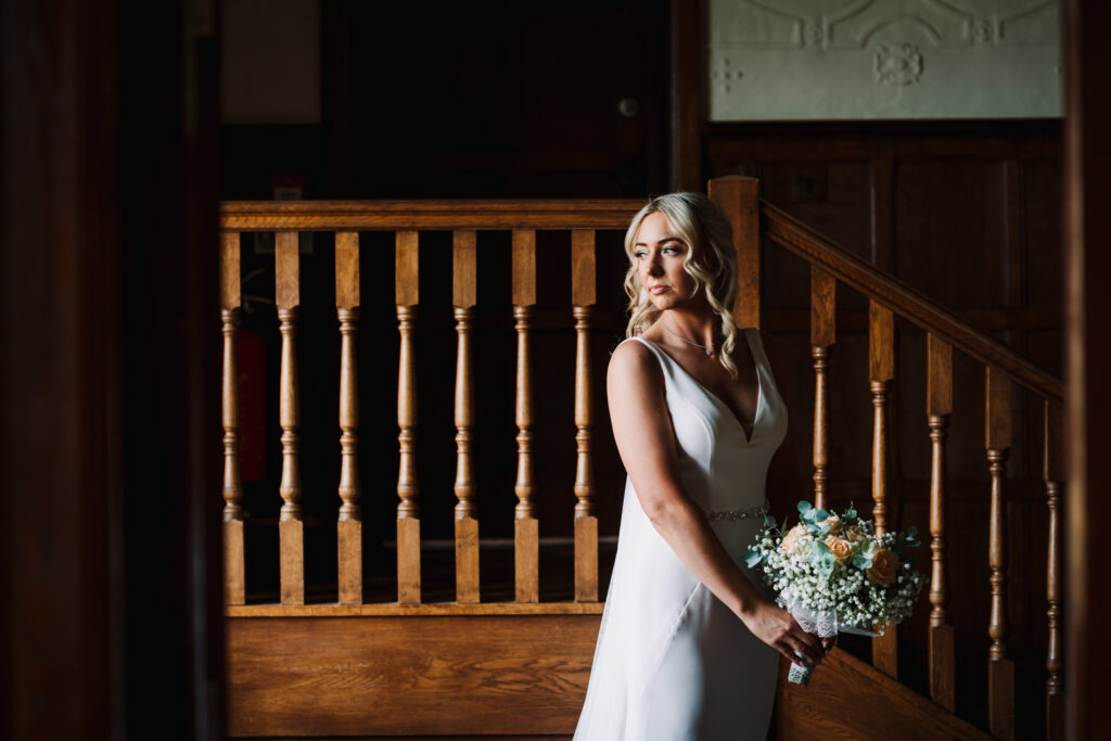 Bride to be stands in window light just before her Fanhams Hall wedding day