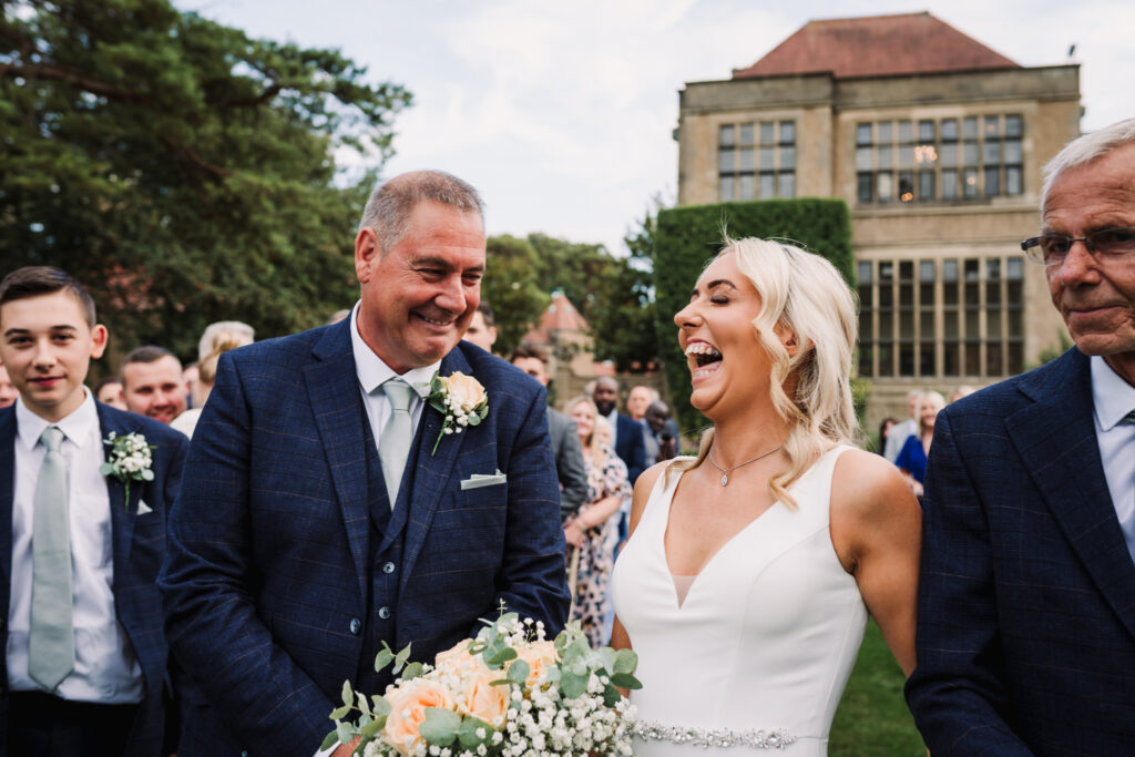 Bride laughs as she sees her husband to be at Fanhams Hall wedding