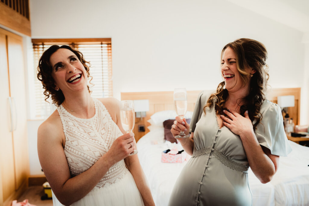 Hertfordshire wedding photographer captures bride and her best friend laughing at Tewin Bury