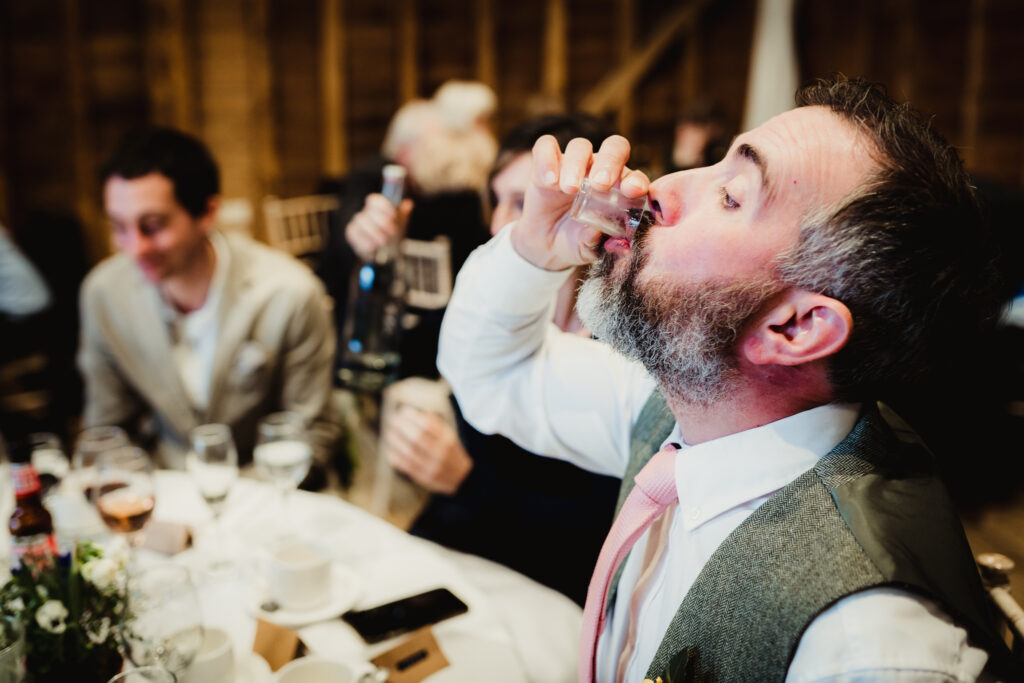 Best man does a limoncello shot at Tewin Bury Farm wedding