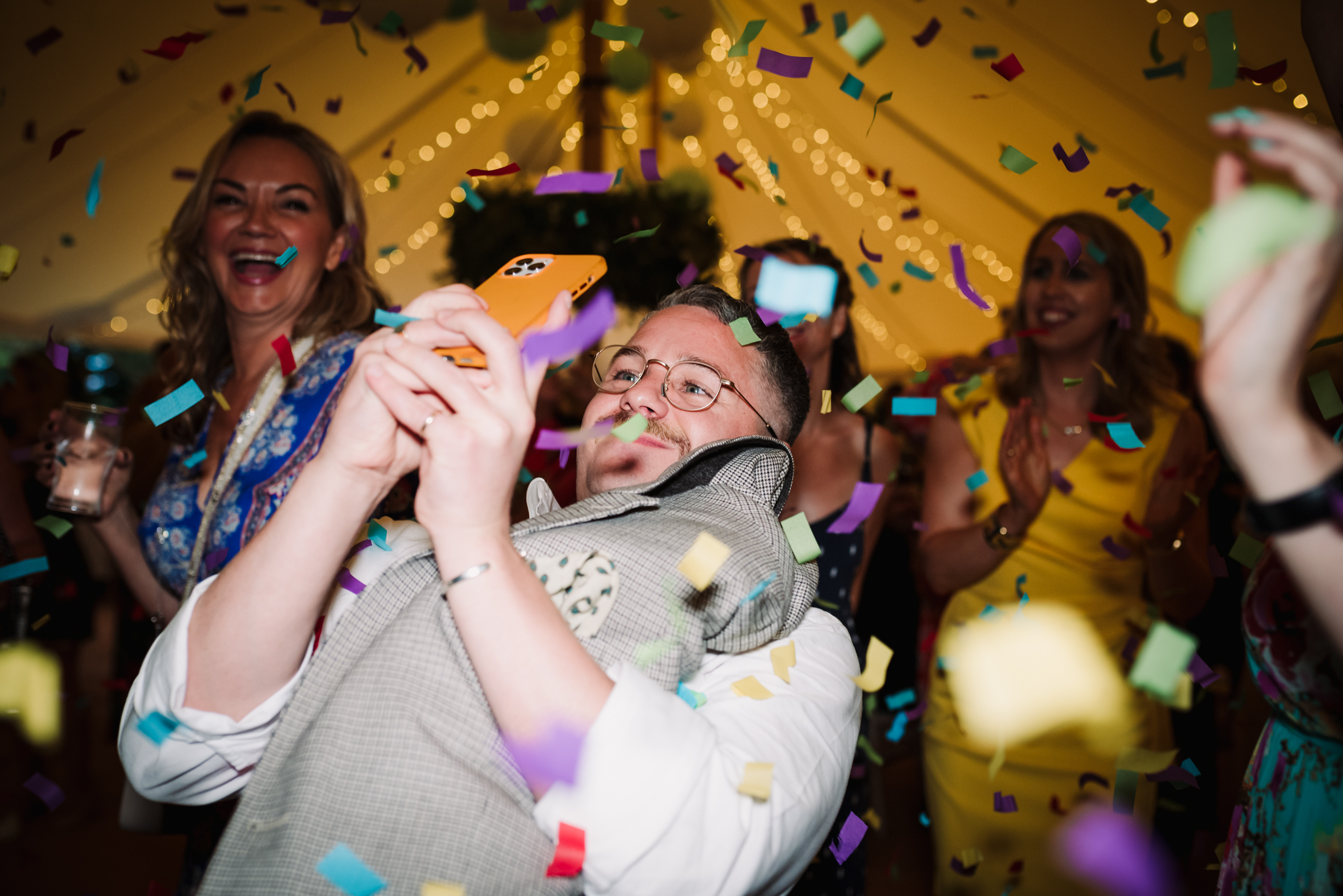 Wedding guests takes a photograph of confetti canon at wedding reception