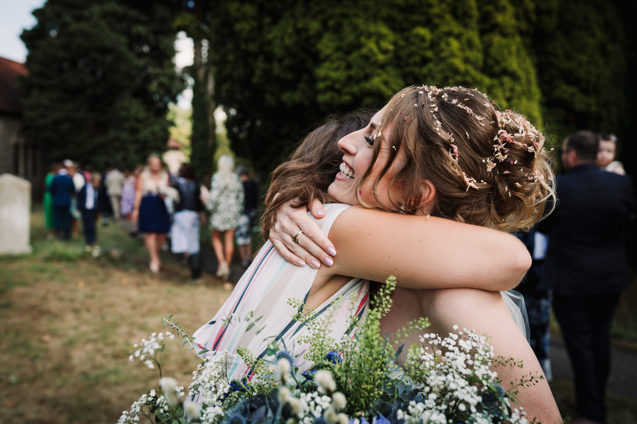 bride hugs a guest at garden party wedding reception