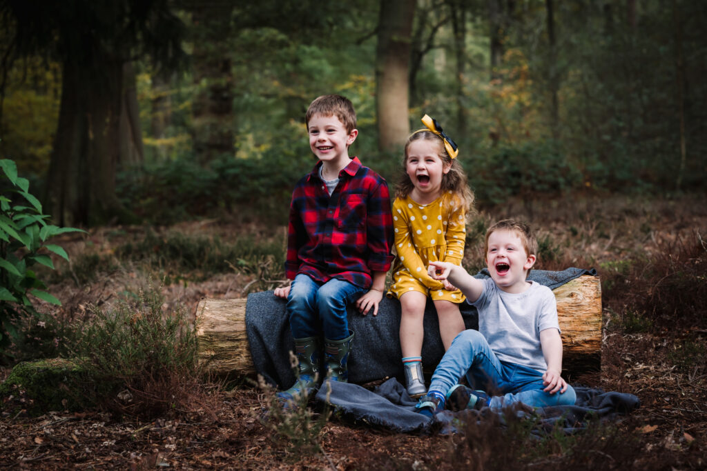 Cousins giggle together during their family photography in hertfordshire woodland setting