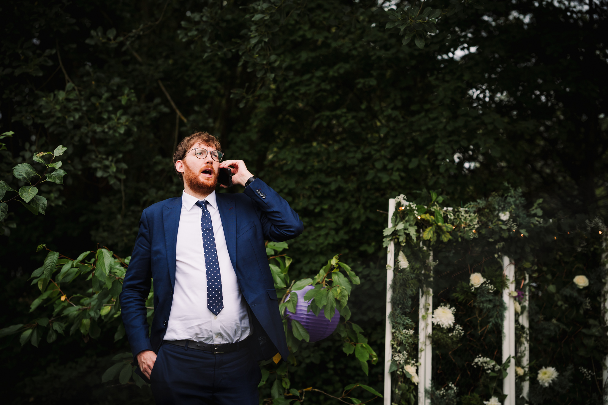 hertfordshire wedding guest has a phone conversation during the garden party reception